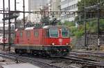 In Warteposition unter einem Schaltposten (SchaPo): Re 4/4 II 11214 in der Nordeinfahrt von Basel-SBB.