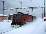 Eine Re 4/4 II fhrt mit einem kurzem Postzug durch Faido am 10.12.2008