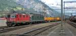 SBB-Cargo: Ein tglicher Gterzug am Gotthard bildet dieser gelbe, welcher am 29.5.09 von der roten Re 4/4  11251 und der grnen Re 6/6 11663  Eglisau  durch Erstfeld gezogen wird. Rechts wird die Re 4/4  11313 an einen Gterzug angekuppelt. Diese Lok diente schon im Januar einmal als Schiebelok am Gotthard.