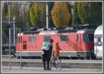 Beide tragen einen Helm, der Eine, weil er schnell unterwgs ist auf dem Fahrrad, der Andere, weil er zwischen die Wagen steigen muss.