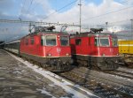 Links Re 4/4 II 11217 mit RE 3819, rechts Re 4/4 II 11164 mit abgestelltem Entlastungzug in Landquart, 26.12.2010.