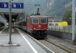 Mit einem Salonwagen am Haken durchfhrt die Re 4/4  11143 am 27.07.11 den Bahnhof Castione-Arbedo.