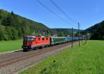 Eine Re 4/4 schiebt einen Nahverkehrszug am 27.08.2012 durch Tecknau Richtung Olten.