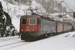 Re 620 065-3, dahinter Re 4/4 II, Re 6/6 und nochmals eine Re 4/4 II ziehen bei leichtem Schneefall einen langen Gterzug talwrts.Gotthard- Nordrampe, Bahnhof Wassen,7.3.2006