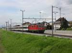 Die Re 4/4 11303 mit einem Reintalexpress am 09.05.2013 bei der Durchfahrt in Au SG