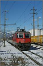 Während die SBB Re 4/4 II 11193 am 19. März 2013 in Cadenazzo durch eine Schneelandenschaft fährt....
