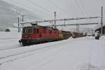 Re 4/4 II 11283 mit Güterzug bei Durchfahrt in Airolo, 07.02.2014.