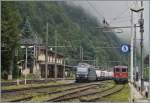 In Iselle wartet die SBB Re 4/4 II 11112 der Autozug 27972 auf die Abfahrt Richtung Brig, während die BLS Re 465 012 mit einem Zug farbrikneuer Auto durchfährt.