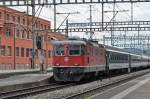 Re 4/4 II 11128 durchfährt den Bahnhof Muttenz. Die Aufnahme stammt vom 22.06.2015.