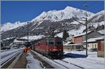 Eine Re 10/10 mit der Spitzenlok 420 265-1 habenmit ihrem Güterzug den Gotthardtunnel hinter sich gelassen und fahren nun durch den Bahnhof von Airolo Richtung Süden.