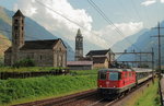 Die Re 4/4 II 11156 durchfährt auf ihrem Weg nach Norden am 13.09.2016 mit einem IR Giornico, im Hintergrund die Kirchen San Nicola (gebaut um 1150) und San Michele, deren Ursprung um 1210 liegt