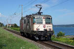 AK-Bobo mit Werbeanstrich als Lokzug am Bielersee.
Re 420 262-8 bei Ligerz am 10. August 2021.
Foto: Walter Ruetsch