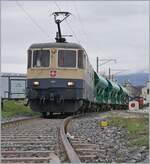 Die IRSI/IGE  Rheingold  Re 4/4 II 11387 (Re 421 387-2) im Dienste der BAM MBC verlässt mit ihrem Kieszug nach Apples das Industriegelände bei Gland.