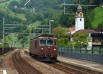 Die Re 4/4 188 der BLS durchfährt am 15.09.2016 als Lz den Bahnhof Sisikon