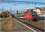 Die SBB Re 460 064-9 fährt mit einem IR nach Brig in Rivaz durch, der Güterschuppen ist verschwunden, die Gleisanlage reduziert worden, immerhin besteht noch mitten im Bahnhof und damit