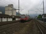 Eine Re 460 mit einem Reisezug auf der Durchfahrt durch Brunnen.