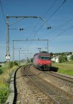 Re 460 mit IC bei Neyruz im sanften Morgenlicht, eingerahmt von alten SBB -Fahrleitungsmasten am 19.