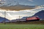 An einem föhnigen Morgen braust im Gegenlicht ein IC von Zürich HB nach Chur mit der Schublok Re 460 071-4 in Reichenburg vorüber.Bild vom 9.11.2015