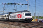 Re 460 075-5, mit der Léman 2030 Werbung, durchfährt den Bahnhof Muttenz.