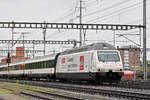 Re 460 052-4, mit der ABB/Gottardo 2016 Werbung, durchfährt bei regnerischem Wetter den Bahnhof Muttenz.