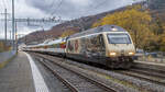 Re 460 019-3 wartet, mit einem Sonderzug aus Bure-Casernes kommend, die Kreuzung mit der S-Bahn in Grellingen BL ab, aufgenommen am Abend des 19.11.2022.