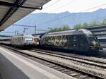 Die Re 460 041  Coop Tatendrang  an einem Zusatzmodul abgestellt mit der Re 460 072  Locarno Film Festival  die am EC nach Hamburg-Altona bereit steht, am 21.6.23 im Bahnhof Interlaken Ost.