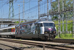 Re 460 028-4, mit einer SBB Personal Werbung, durchfährt den Bahnhof Muttenz.