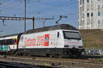 Re 460 098-7, mit einer Gottardo 2016 Werbung, durchfährt den Bahnhof Pratteln.