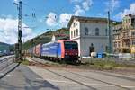 SBB Cargo International Bombardier Traxx 482 018-9 mit KLV am 02.05.20 in Rüdesheim von einen Gehweg aus fotografiert über einen Zaun.