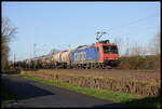 SBB Cargo 482014-8 hat mit ihrem Kesselwagen Zug gerade den Bahnhof Hasbergen durchfahren und ist hier am 23.2.2022 um 9.41 Uhr am Ortsrand von Hasbergen in Richtung Osnabrück unterwegs.