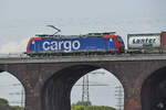 Auf der Hochfelder Eisenbahnbrücke zieht die Elektrolokomotive 482 010-6 einen Containerzug, so gesehen Ende August 2022 in Duisburg.