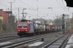 Die 482 028-8 Chemoil zieht einen langen Containerzug durch Kln-West.