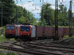 Am 06.08.2012 fhrt 482 000-7 mit einem Containerzug an der abgestellten 185 596-4 von Crossrail vorbei durch das Gleisvorfeld von Aachen West.