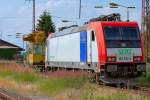 Abgestelltes Spitzke Mehrzweckarbeitsgert und eine E-Lok aus der Schweiz mit Werbung fr ein sterreichisches Logistikunternehmen auf dem Gleis des Bahnhofs Anklam.