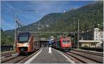 Während der SOB RABe 526 208  TRAVERSO  als RE  Treno Gottardo  2320 von Locarno nach Basel SBB unterwegs ist und in Faido hält, fährt die SBB Re 484 009 mit ihrem Güterzug nach