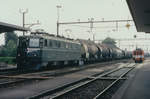 SBB/ASm: Ae 6/6 11408 SOLOTHURN vor einem Ölzug beim Passieren des Bahnhofs Niederbipp im März 1998. Besondere Beachtung gilt der damals noch im Betrieb stehenden Rollbockanlage mit dem auf den nächsten Einsatz warteten De 4/4 321.
Foto: Walter Ruetsch 