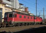 Eine Re 4/4 II und die Re 6/6 11678 durchfahren den Bahnhof Pratteln.