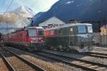 Den Bahnhof Erstfeld durchfährt Re 10/10 mit dem aufgeklebten Schnauz Re 6/6 11626 in Front und einem Containerzug und begegnet dabei dem Originalschnauz Ae 6/6  Uri  11402 ,links versucht die