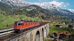 Die SBB Cargo Re 6/6 11672  Balerna  und Re 4/4 11332 überqueren, mit ihrem leeren Holztransportzug von Verzuolo nach Basel, das Kanderviadukt oberhalb von Frutigen.