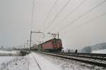 Die Re 6/6 11673  Cham  und eine Re 4/4 berqueren gerade die Reussbrcke mit einem Kesselcontainerzug, am 24.2.04 auf der Strecke Oberrti - Rotkreuz