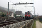 Die Re 620 034-9  Aarburg-Oftringen  mit ihrem Güter auf der Fahrt nach Lausanne beim Passieren des Weilers Chavannes am 26. November 2020.
Im Nebel nur noch leicht erkennbar ist die bekannteste Kirche vom Seeland, das Wahrzeichen von Ligerz.
Foto: Walter Ruetsch