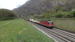 Die Re 620 025 der SBB Cargo zog am 22. April 2021 einen gemischten Güterzug, vermutlich vom RBL nach Chiasso, durch Claro. Zu erst hinter der Lok ein Baukran der Rhomberg-Sersa Rail Group.