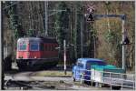 Die Re 6/6 11640  Mnchenstein  entschwindet durch eine scharfe Rechtskurve beim Bahnhof Hntwangen-Wil in den Wald Richtung Kiesverladeanlage.