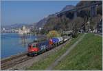 Vor dem Hintergrund des Château de Chillion fährt die SBB Re 620 013-3 mit einem Güterzug, dessen erster Wagen farblich besonders gut zur Loks passt, Richtung Wallis.