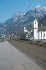 Für mich der unbestrittene  Star  unter den Lokomotiven ist die Re 6/6 der SBB. Hier durchfährt sie mit dem Schnellzug  Barbarossa  Stuttgart/Schaffhausen - Milano den Bahnhof Flüelen Richtung Gotthard.
Flüelen, 14. April 1980; Canon AE-1, Canoscan, Gimp