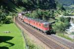 Eine Re 10/10 zieht einen schweren Gterzug bergwrts die Gotthard-Rampe hinauf.