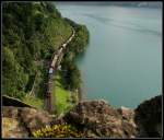 Re 10/10 mit viel Gter am Urnersee mit Gumpischbachbrcke.