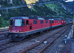 Eine Re 10/10, bestehend aus den Lokomotiven Re 4/4 II 11342 und Re 6/6 11676  Zurzach , durchfährt in der Dämmerung, auf dem Weg in Richtung Erstfeld, den Bahnhof Göschenen.