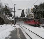 Eine  Re 10/10  wirbelt bei der Durchfahrt in Vevey allerlei Schnee auf.