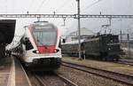 Der SBB/Trenitalia TILO RABe 524 106 erricht im Bild als RE aus Milano C. ausnahmsweise auf Gleis 1 den Bahnhof Erstfeld. 
Grund des Gleiswechsels war der rechts im Bild zu sehende Ae 4/7 10987 mit einem Sonderzug aus Nürnberg/Frankfurt nach Locarno, der das Gleis 4 blockierte. Auf Gleis 3 wird in Kürze sowieso der IR Olten/Zürich HB - Erstfeld ankommen.